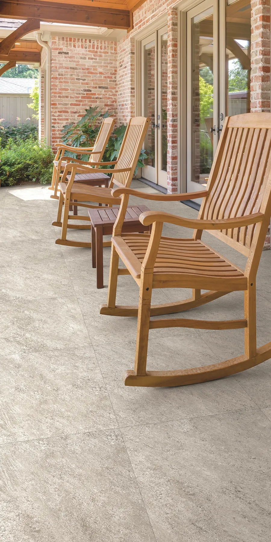 Beige square tiles with wooden rocking chairs acting as a patio, suggesting why tiles are better than decking. 