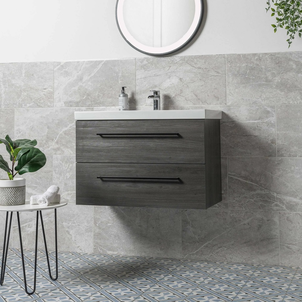 Grey bathroom wall tiles with blue patterned floor and grey wall mounted vanity basin.