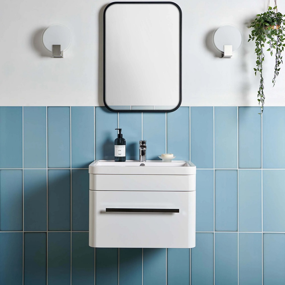Vibrant blue wall tiles as splashback in bathroom with wall mounted basin vanity and matt black accents. 