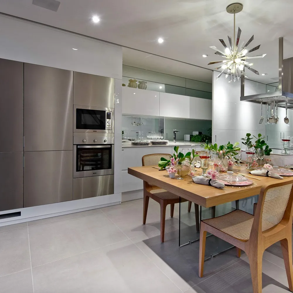 Modern kitchen with grey and white scheme and oak wood dining table and chairs, dining table is fully dressed. 