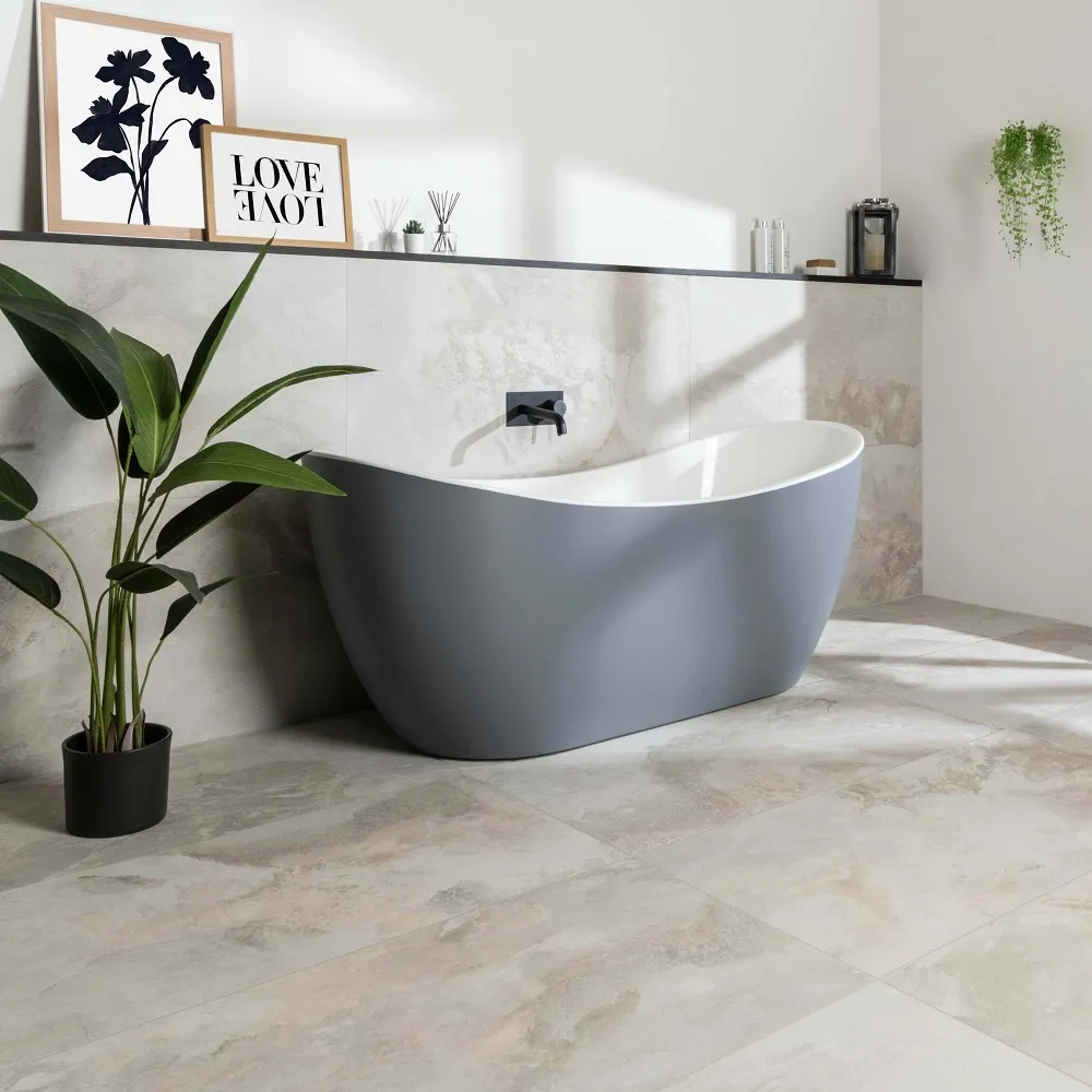 Bathroom with marble floors and wall with grey modern freestanding bath in centre.