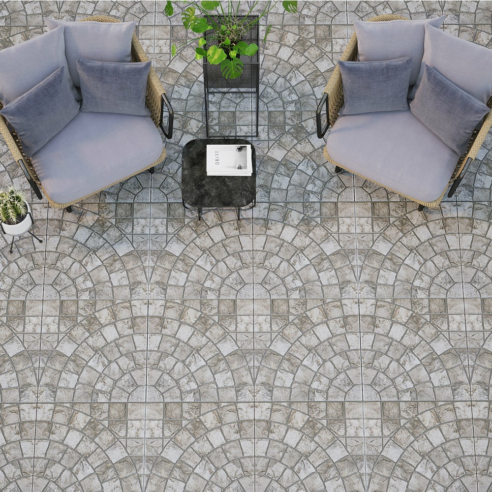 A charming garden setting with an intricate cobblestone porcelain tile design in a wave pattern, accompanied by comfortable armchairs with plush grey cushions and a sleek black side table, all enhanced by potted green plants. 